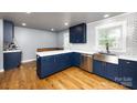 Modern kitchen featuring custom blue cabinets, stainless steel appliances, and quartz countertops at 8210 Lantana Dr, Denver, NC 28037