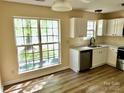 Bright kitchen featuring white cabinets, stainless steel appliances, and a large window for natural light at 8608 Warwick Crest Ln, Charlotte, NC 28215