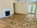 Bright living room with tile floors, a cozy fireplace, and access to a patio through glass doors at 8608 Warwick Crest Ln, Charlotte, NC 28215