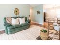 Cozy living room features a green couch, light green walls, a decorative mirror and hardwood floors at 905 Mount Olivet Rd, Kannapolis, NC 28083