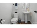 Stylish half bathroom featuring a pedestal sink, oval mirror, and modern fixtures at 9424 Avery Lilac Ln # 83, Fort Mill, SC 29707