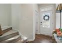 Bright entryway featuring a decorative front door, wood floors, and staircase to the upper level at 9424 Avery Lilac Ln # 83, Fort Mill, SC 29707