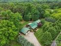 Aerial view of a charming log home surrounded by lush greenery and mature trees at 10583 Earnhardt Lake Rd, Davidson, NC 28036