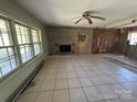Interior view of living room with brick fireplace, ceiling fan and tile flooring at 10625 Cool Springs Rd, Woodleaf, NC 27054