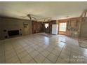Interior view of living room with brick fireplace, ceiling fan and tile flooring at 10625 Cool Springs Rd, Woodleaf, NC 27054