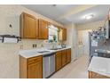 Efficient kitchen with wood cabinetry, stainless steel dishwasher, and adjacent laundry area at 130 Overcreek Rd, Mooresville, NC 28117