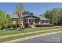 Inviting home showcasing a covered porch, beautiful landscaping, and a lush green lawn at 1306 Kings Bottom Dr, Fort Mill, SC 29715