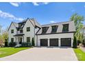 Beautiful two-story home boasting a three-car garage, manicured lawn and timeless architectural details at 1446 Townes Rd, Charlotte, NC 28209
