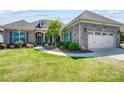 Charming brick home featuring a well-manicured lawn and two-car garage at 17315 Langston Dr, Charlotte, NC 28278