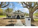 Charming home featuring covered porch with black railings and a well-maintained lawn at 221 Palmer St, Albemarle, NC 28001