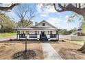 Beautifully renovated white house with black accents, porch and manicured yard on a sunny day at 221 Palmer St, Albemarle, NC 28001