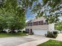 Well-maintained two-story home with a long driveway, attached garage, and lush green lawn at 2316 Highland Park Dr, Charlotte, NC 28269