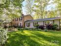 Lovely brick home with a well-maintained lawn, mature trees, and classic architectural details at 3232 Kale Ln, Matthews, NC 28105