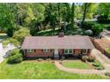 Aerial view of brick home with manicured lawn, colorful landscaping, and mature trees at 4925 Seacroft Rd, Charlotte, NC 28210