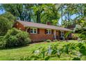 Beautiful brick home with lush landscaping, mature trees, and a well-maintained lawn at 4925 Seacroft Rd, Charlotte, NC 28210