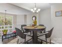 Cozy dining room with modern chandelier, seating for four, and neutral color palette at 7324 Pebblestone Dr # E, Charlotte, NC 28212