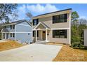 Charming two-story home showcasing neutral siding, black shutters, and a well-manicured front yard at 74 Snyder Ne Ct, Concord, NC 28025