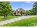 Spacious home with a long driveway, brick facade, mature trees, and well-maintained lawn at 7600 Brookmont Ln, Waxhaw, NC 28173