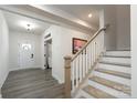 Inviting foyer with wood-look floors, staircase, and front door featuring glass accents at 8419 Everwood Ave, Huntersville, NC 28078