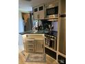 Galley kitchen features stainless appliances, white cabinets and modern fixtures at 103 Hidaway Trl # 99A, Mount Gilead, NC 27306