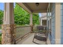 Charming front porch with rocking chairs, stone pillars, and wood railing for relaxing outdoors at 10423 Drake Hill Dr, Huntersville, NC 28078