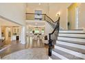 Grand foyer showcasing a curved staircase, hardwood floors, and an open floor plan with bright natural light at 133 Crooked Branch Way, Troutman, NC 28166