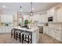 Elegant kitchen with white cabinetry, granite countertops, stainless steel appliances, and a center island with bar seating at 133 Crooked Branch Way, Troutman, NC 28166