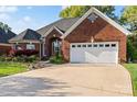 Charming brick home with an attached two-car garage, mature trees, and a well-maintained front lawn at 1511 Elkhart Cir, Gaston, NC 28054