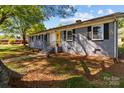 Gray brick home featuring black shutters, landscaping, and a welcoming entryway under a canopy of trees at 1860 Rosemont St, Salisbury, NC 28144