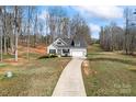 Aerial view of a well-maintained home with a long driveway surrounded by lush greenery and mature trees at 1870 Beth Haven Church Rd, Denver, NC 28037