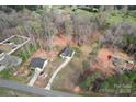 Aerial shot featuring a charming house with a long driveway surrounded by a lush, wooded landscape at 1870 Beth Haven Church Rd, Denver, NC 28037