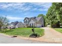 Inviting home with a lush green lawn, complemented by mature trees and a long driveway leading to the garages at 1930 Southridge Dr, Belmont, NC 28012