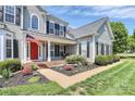 Beautiful home featuring a red front door, meticulously landscaped flowerbeds, and a welcoming covered front porch at 1930 Southridge Dr, Belmont, NC 28012
