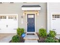 Close-up of a stylish blue front door with a covered porch and an ADT security system sign at 2051 Langer St, Charlotte, NC 28214