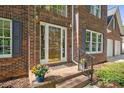 Close-up of the front door with a brick stoop decorated with colorful potted flowers at 210 35Th Ne Ave, Hickory, NC 28601