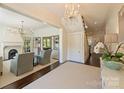Bright foyer with elegant chandelier, flows into a cozy living space with fireplace at 2101 Dilworth W Rd, Charlotte, NC 28203