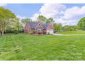 Beautifully landscaped yard surrounds this charming brick home with an expansive green lawn at 2104 Planters Knoll Dr, Monroe, NC 28110