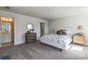 Bedroom featuring neutral carpet, a queen bed, and an ensuite bathroom entrance at 2124 Barrowcliffe Nw Dr, Concord, NC 28027