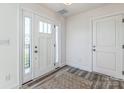 Bright entryway showcasing a white door with sidelights and wood-look flooring at 2124 Barrowcliffe Nw Dr, Concord, NC 28027
