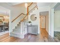Inviting foyer featuring hardwood floors, staircase, and an elegant pendant light at 2221 Hamilton Mill Rd, Charlotte, NC 28270