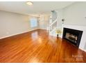 Open-concept living room with hardwood floors, fireplace, and staircase at 3129 Brockhampton Ct, Charlotte, NC 28269