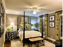 Comfortable bedroom with four-poster bed, neutral walls, ceiling fan, and stylish decor at 3718 Barclay Downs Dr, Charlotte, NC 28209