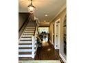 Inviting entryway with hardwood floors, staircase, and views into the dining room with natural light at 3718 Barclay Downs Dr, Charlotte, NC 28209
