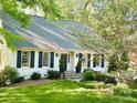 Beautiful landscaped front yard of home with black shutters, and a stone pathway at 3718 Barclay Downs Dr, Charlotte, NC 28209