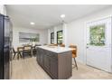 Bright kitchen featuring a dining area, white cabinets, island seating and door to backyard at 3801 Woodleaf Rd, Charlotte, NC 28205