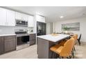 Modern kitchen featuring stainless appliances, white cabinets, and a center island with seating at 3801 Woodleaf Rd, Charlotte, NC 28205