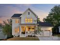 Attractive two-story home with a welcoming front porch and a convenient three-car garage at dusk at 4012 Spring Cove Way, Belmont, NC 28012