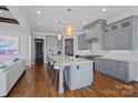 Modern kitchen with a large island, gray cabinets, stainless steel appliances, and hardwood floors at 4109 Arbor Spring Ct, Belmont, NC 28012