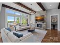 Bright living room with stone fireplace, beamed ceilings, water views, and elegant decor for comfortable living at 4109 Arbor Spring Ct, Belmont, NC 28012