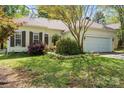 Inviting single-story home with lush landscaping and an attached two-car garage at 5311 Courtfield Dr, Indian Trail, NC 28079